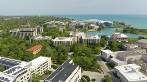 Drohne-Fliegt-An-Einem-Heißen-Sommertag-über-Der-Prestigeträchtigen-Universität-Im-Nordwesten,-Wobei-Der-Seebrunnen-Wasser-Herausschießt