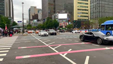 Toma-En-Cámara-Lenta-De-Muchos-Automóviles-En-Un-Cruce-Frecuentado-En-Seúl-Y-En-Un-Cruce-De-Peatones-Durante-El-Día