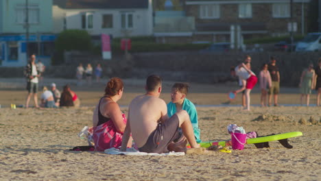 Family-On-The-Sandy-Shore-During-Summer-In-Perranporth-Beach,-Cornwall,-England