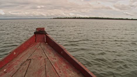 Looking-over-the-bow-of-a-wooden-boat-as-it-navigates-the-Amazon-River-in-Brazil