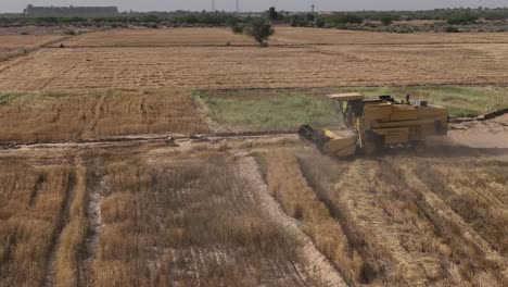 Filmischer-Shot-Harvester,-Der-Auf-Einem-Feld-Fährt-Und-Getreide-Pflügt
