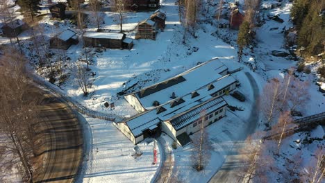 Hallingdal-Folk-Museum-close-to-Rukkedalsvegen-road-in-Nesbyen-Hallingdal-Norway---Aerial-approaching-museum-buildings-during-winter