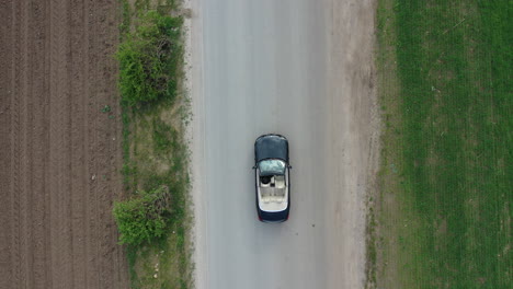 Vogelperspektive-Luftaufnahme-Eines-Cabrio-Autos-Und-Fahrers,-Die-Sich-Auf-Einer-Landstraße-Bewegen