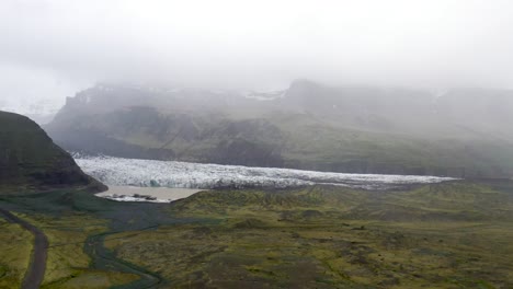 Island-Gletscher-Weitwinkelaufnahme-Mit-Wasser-Und-Grünem-Gras-Mit-Drohnenvideo,-Das-Sich-Vorwärts-Bewegt
