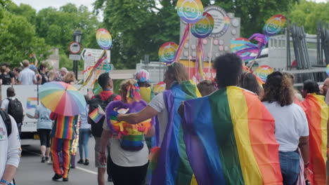 Manifestantes-Del-Orgullo-Ondean-Pancartas-Y-Banderas-Arcoiris-Desde-Atrás-En-Cámara-Lenta