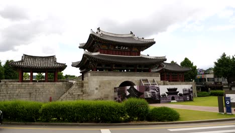 Slow-motion-shot-of-car-driving-on-roundabout-around-Temple-Area-with-Pungnammun-Gate-in-Jeonju-in-South-Korea---Wide-shot