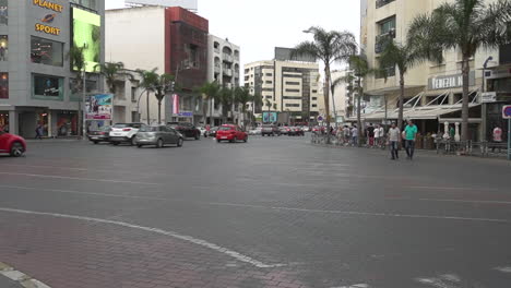 Menschen-überqueren-Die-Straße-Bei-Gegenverkehr,-Geschäftsviertel-Maarif