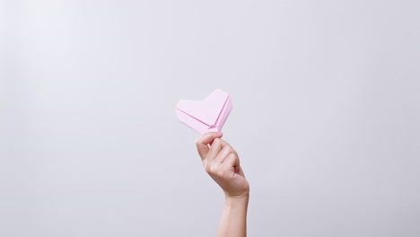 Woman's-holding-a-paper-heart-in-white-studio-background-with-copy-space