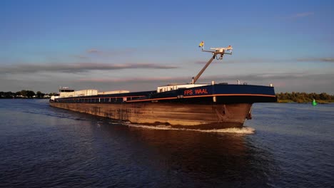Aerial-Starboard-And-Forward-Bow-View-Of-Forward-Bow-Of-FPS-Waal-Cargo-Container-Vessel-Travelling-On-Oude-Maas-During-Golden-Hour