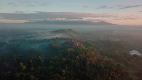 Vista-De-Pájaro-Sobre-El-Templo-De-Borobudur-Y-Las-Montañas-Circundantes-Al-Amanecer