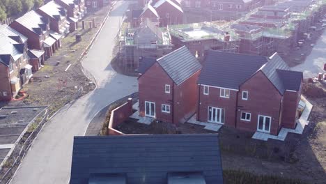 Aerial-view-morning-sunrise-over-empty-British-suburban-housing-development-building-site