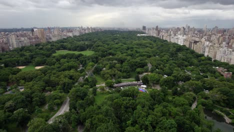 Vista-Aérea-Sobre-El-Parque-Central,-Revelando-La-Pista-Wollman,-En-La-Nublada-Nueva-York,-EE.UU.---Inclinación,-Disparo-Con-Drones