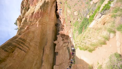 Turistas-Caminando-Alrededor-De-La-Casa-Larga-Que-Habita-En-El-Acantilado-En-El-Parque-Nacional-Mesa-Verde,-Vertical