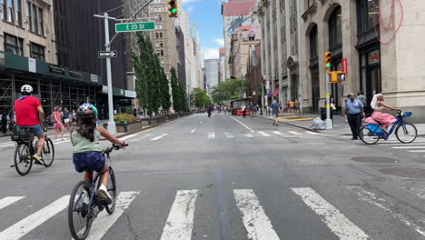 Kippen-Sie-Vom-Blauen-Himmel-Nach-Unten-Zu-Menschen,-Die-Auf-Einer-Geschlossenen-Straße-In-Manhattan,-New-York-City,-Fahrrad-Fahren