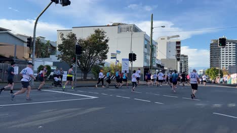 Participants-running-for-Bridge-to-Brisbane-fundraise-event-to-raise-funds-for-charity,-showing-love-and-support-for-good-cause,-handheld-motion-editorial-shot