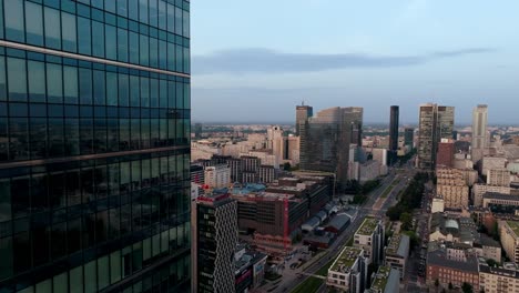 Vista-Aérea-De-Varsovia,-Polonia,-Volando-Por-Las-Ventanas-De-Los-Rascacielos,-Rascacielos-Modernos-Y-Tráfico-De-La-Avenida-Prosta,-Disparo-De-Drones