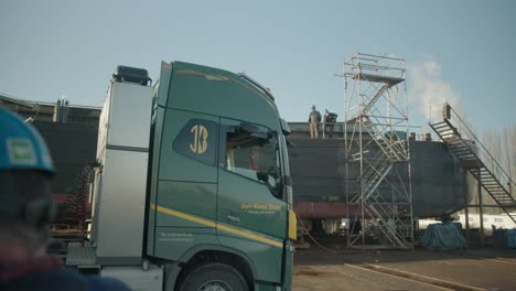 Enorme-Camión-Conduciendo-Lentamente-Hacia-Un-Astillero-De-Construcción-De-Barcos