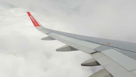 Shot-of-wing-of-an-airplane-facing-turbulance-while-flying-through-white-clouds-in-Mexico-city,-Mexico-at-daytime