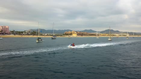 Turistas-Montando-Motos-Acuáticas-Y-Practicando-Deportes-Acuáticos-De-Aventura-Al-Aire-Libre-En-Las-Aguas-De-Cabo-San-Lucas,-México