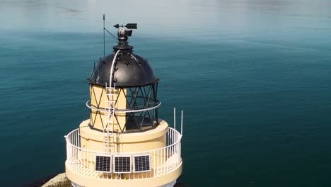 Close-up-aerial-orbit-shot-of-the-Tobermory-Lighthouse-in-the-Isle-of-Mull-Coast