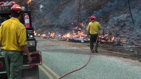 Mann-Zieht-Einen-Schlauch-Aus-Einem-Feuerwehrauto-Und-Bekämpft-Waldbrände-Im-Westen-Der-USA-–-Handheld-Ansicht