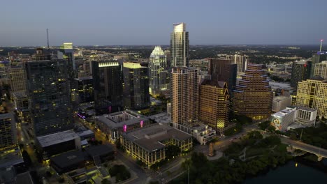 Aerial-view-away-from-downtown-Austin,-dusk-in-Texas,-USA---pull-back,-drone-shot