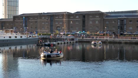 Canary-Wharf,-London,-Vereinigtes-Königreich-–-August-2022-–-Zwei-Schwimmende-Ringe-Mit-Einem-Grill-In-Der-Mitte-Treiben-Langsam-Im-Kanal-Im-Wunderschönen-Und-Warmen-Sonnenuntergang-Im-Sommer-In-London