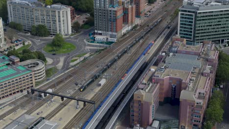 Reading-United-Kingdom-July-2022-Aerial-establishing-shot-of-long-train-coming-into-Reading-train-station