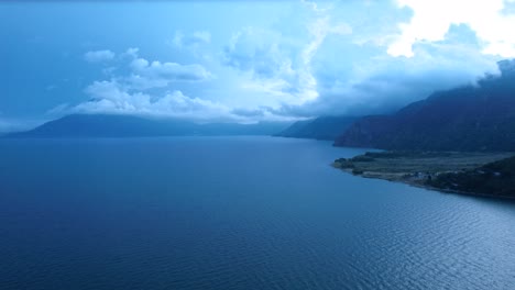 Drohnenflug-Aus-Der-Luft-über-Den-Atitlan-See-In-Sonniger-Aussicht-Und-Vulkanischem-Berg-Im-Hintergrund,-Guatemala