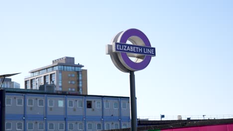 Canary-Wharf,-London,-Vereinigtes-Königreich---August-2022---Ein-Mast-Und-Ein-Zeichen-Der-Neuen-Elizabeth-Linie-In-Lila-Farbe-An-Einem-Schönen,-Klaren,-Sonnigen-Morgen-In-Canary-Wharf