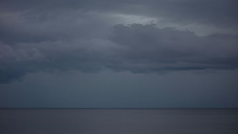 Dark-depressive-cloudscape-and-rain-over-gray-sea-time-lapse