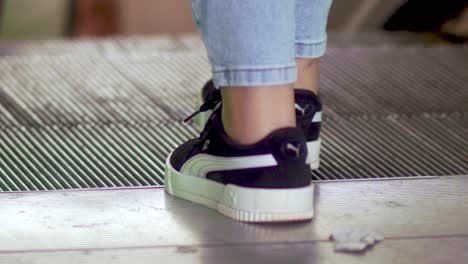 People-stepping-on-to-the-escalator-to-the-metro---feet-only-in-slow-motion