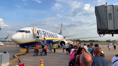 Personas-Que-Abordan-Un-Avión-De-Ryanair-En-Un-Aeropuerto-Internacional-En-Málaga,-España,-Aviones-De-Ryanair,-Personas-Que-Se-Van-De-Vacaciones,-Tomas-De-4k