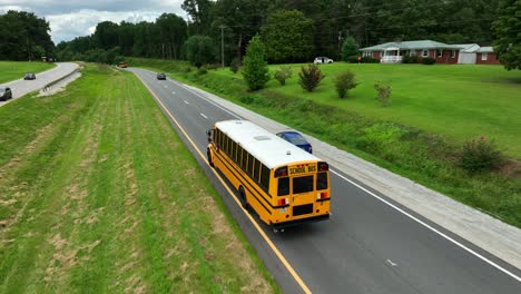 Aerial-tracking-shot-of-school-bus-on-two-lane-highway