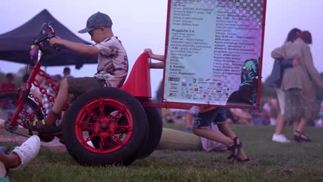 Niños-Jugando-Con-Una-Enorme-Bicicleta-única-En-El-Festival-De-Rusne,-Lituania