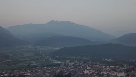 Aerial-panoramic-view-of-Levico-Terme,-Italy,-during-sunrise-with-drone-panning-left-to-right