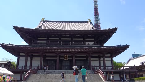 Zojo-ji-Temple,-Tokyo-Tower-and-people-walking-to-the-Zojo-ji-Temple