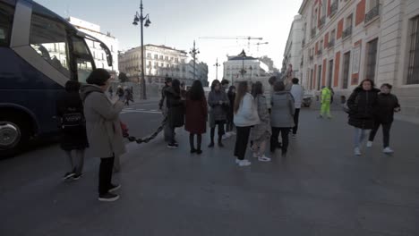 Asian-Tourists-in-a-guided-tour,-visiting-Puerta-del-Sol-KilÃ³metro-Cero-in-Madrid,-starting-point-of-roads-is-Spain