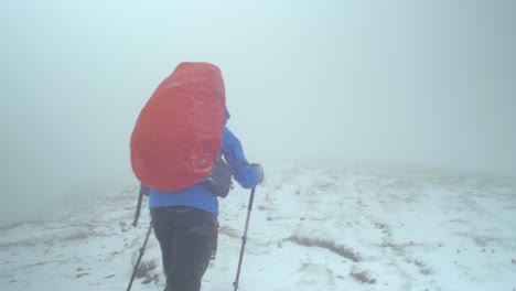 Picos-Alpinos-Rocosos,-Paisaje-De-Las-Montañas-Tatra-Eslovacas,-Toma-Manual-En-Cámara-Lenta-Siguiendo-A-Una-Excursionista-Caminando-Por-Un-Sendero-En-Una-Tormenta-De-Nieve