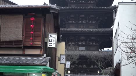 Zoom-out-of-the-Yasaka-Pagoda-in-the-geisha-district-streets-of-Kyoto-and-tourists-walking-around-in-traditional-clothes-kimono