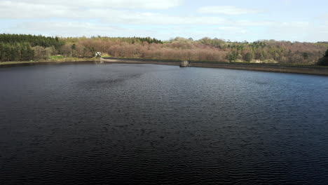 Aerial-Flyover-of-Fewston-Reservoir-Zooming-in-to-Reveal-Lakeside-House-with-Car-Crossing-Dam