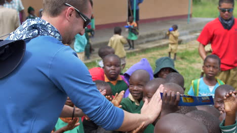 Afrikanische-Kinder-Begrüßen-Fröhlich-Einen-Weißen-Mann-Mit-Begeisterten-High-Fives