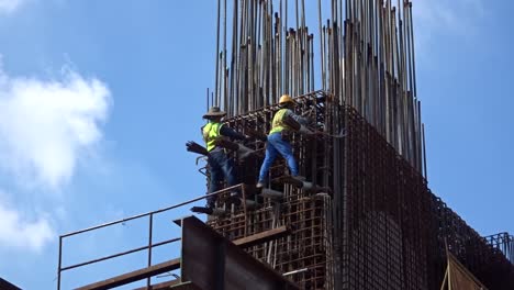 Bauarbeiter,-Die-In-Der-Höhe-Arbeiten-Und-Auf-Der-Baustelle-Stahlbewehrungsstäbe-Herstellen