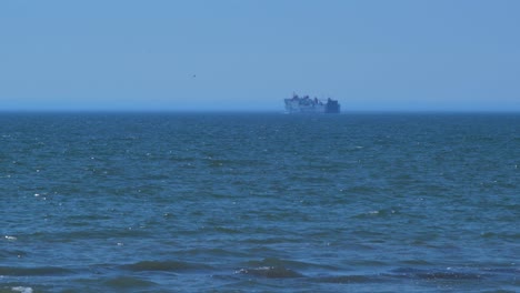 Ro-ro-passenger-ferry-in-sea-in-hot-sunny-day,-wide-shot-from-a-distance