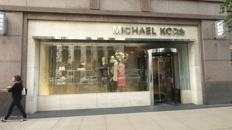 Front-store-view,-Michael-Kors-front-store,-showcase-view,-Michigan-Avenue,-Chicago,-United-States,-Usa,-Tourists-and-people-shopping-and-passing-in-street