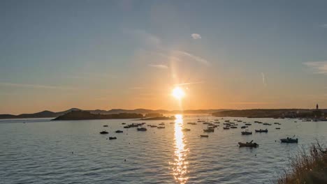 Zeitraffer-Der-Küste-Mit-Booten-Im-Wasser-Und-Sonnenuntergang-Im-Hintergrund