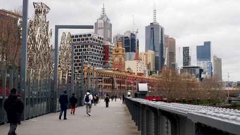 Melbourne-tourists-walking-bridge-heading-to-Flinder-Street-Station-during-daytime