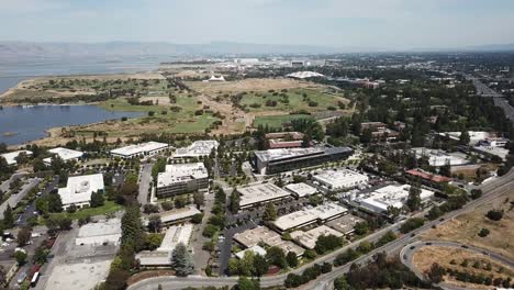 Vista-Aérea-De-Pájaro-De-Las-Oficinas-Tecnológicas-Corporativas-Volar-Hacia-Adelante-Google-Campus-Costa-Anfiteatro-Lago