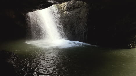 Versteckte-Höhle-Fällt-In-Zeitlupe-Fest,-Natürlicher-Brückenwasserfall-Springbrook,-Queensland