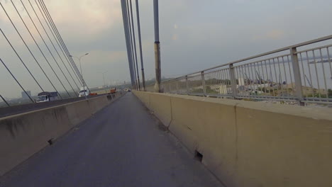 3-De-3-Partes-Del-Cruce-Del-Puente-Phu-My-En-Motocicleta-Que-Muestran-El-Acceso,-La-Estructura-Del-Puente,-Otros-Vehículos-Y-El-Transporte-Marítimo-En-El-Río-De-Abajo